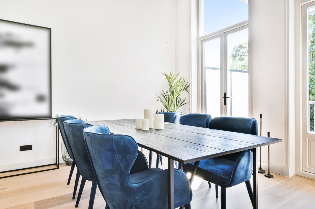 Dining table and chairs near windows in a room full of natural light