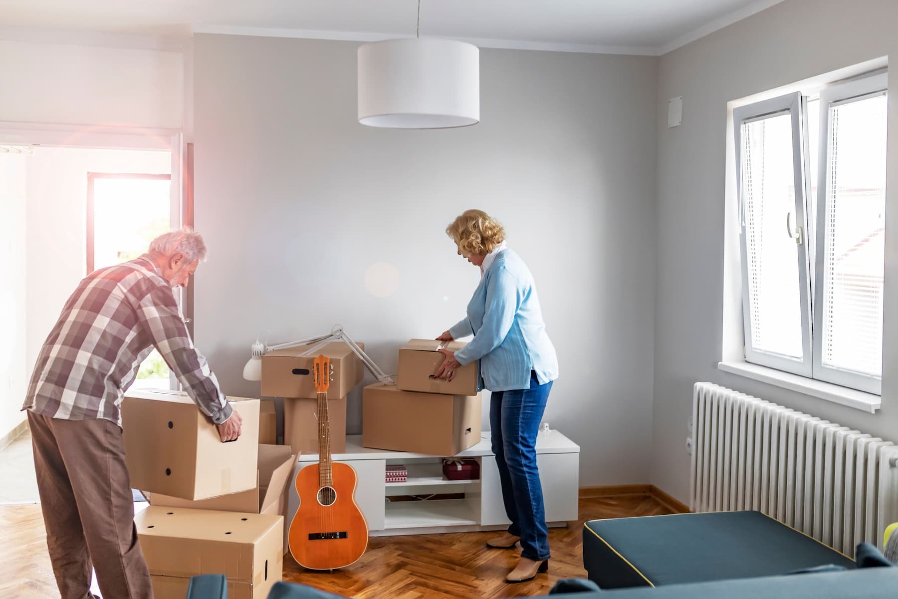 An elderly couple packing to move. Downsizing report for seniors